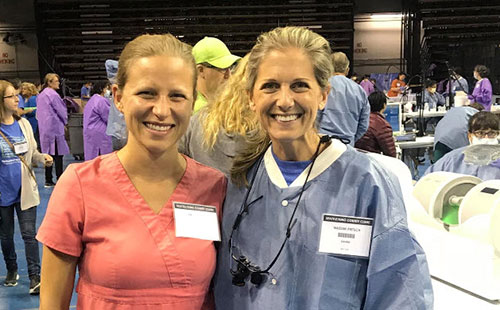 two smiling women at a dental convention