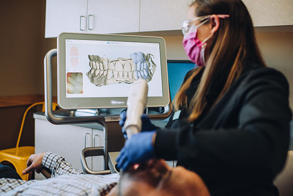 dental staff member taking images of a patient's mouth