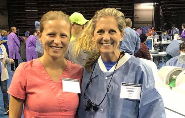 two smiling women at a dental conference